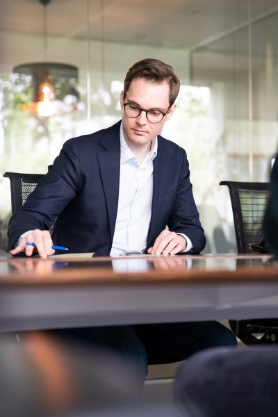 Unternehmensberater Jannik Würz schaut auf Unterlagen auf Schreibtisch